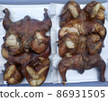 Delicious smoked chickens lies on a tray on foil. 86931505