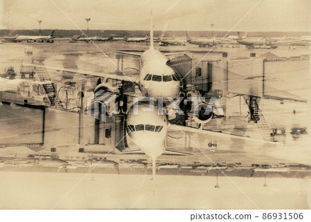The plane stands next to the passenger boarding sleeve. 86931506