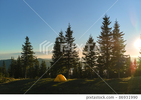 Aerial view of tourist camping tent on mountain campsite at bright sunny evening. Active tourism and hiking concept 86931990