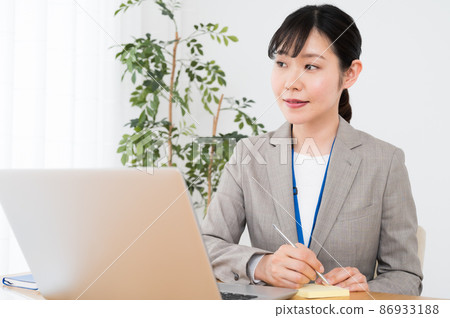 A woman taking notes on sticky notes at work 86933188