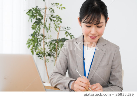 A woman taking notes on sticky notes at work 86933189