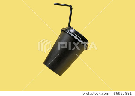Paper coffee container with black lid on yellow background. Copy space Paper coffee container with black lid on yellow background. Copy space 86933881