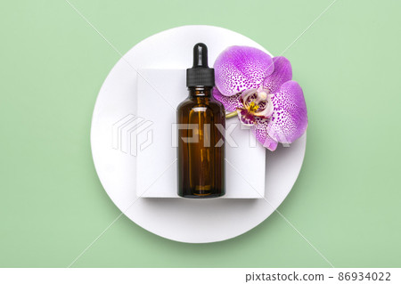 glass cosmetic bottle with moisturizing natural oil, Orchid lie on white podium isolated on green background Top view Flat lay Eco, bio, zero waste product concept Copy space Mock up 86934022