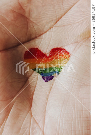 heart-shaped rainbow pride flag in the hand heart-shaped rainbow pride flag in the hand 86934197
