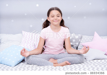 Meditate before go to bed. Girl child sit on bed Meditate before go to bed. Girl child sit on bed 86934366