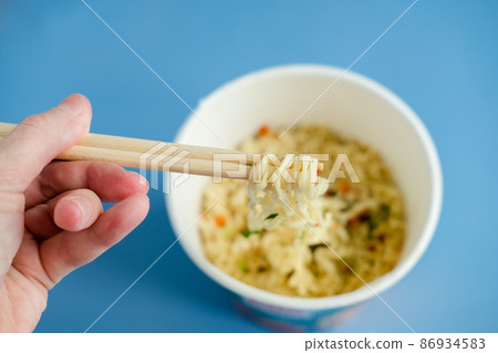 instant noodles with wooden chopsticks on a blue background, top view. Korean national dish. instant noodles with wooden chopsticks on a blue background, top view. Korean national dish. 86934583