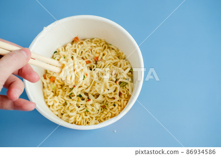 instant noodles with wooden chopsticks on a blue background, top view. Korean national dish. 86934586