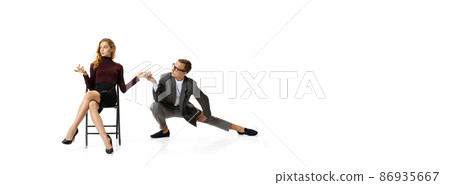 Flirt at work space. Two stylish office workers in business suits isolated on white background. Human rights, diversity, relation, fashion and business concept Flirt at work space. Two stylish office workers in business suits isolated on white background. Human rights, diversity, relation, fashion and business concept 86935667