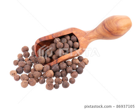 Allspice in wooden scoop, isolated on white background. Jamaican pepper, pimento berry, allspice peppercorns or myrtle pepper. Allspice in wooden scoop, isolated on white background. Jamaican pepper, pimento berry, allspice peppercorns or myrtle pepper. 86937105