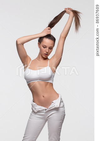 Confident fit lady in seamless bra looking at camera against white background 86937689