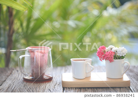 Rose tea and tea strainer filter pot and flowers on wooden tray Rose tea and tea strainer filter pot and flowers on wooden tray 86938241