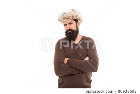 serious mature guy with beard in earflape hat crossed hands isolated on white, winter fashion. serious mature guy with beard in earflape hat crossed hands isolated on white, winter fashion. 86938692
