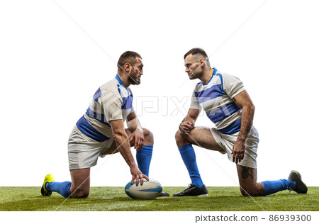 Dynamic portrait of male rugby players playing rugby football on grass field isolated on white background. Sport, activity, health, hobby, occupations concept 86939300