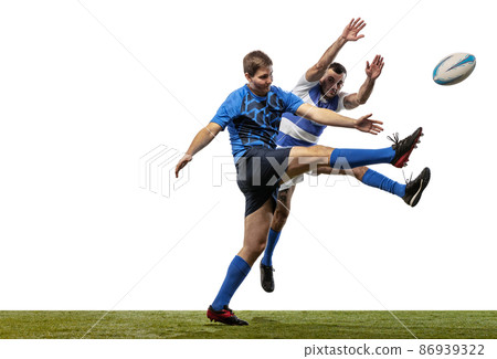 Two athletes, rugby players playing rugby football on grass flooring isolated on white background. Sport, activity, health, hobby, occupations concept Two athletes, rugby players playing rugby football on grass flooring isolated on white background. Sport, activity, health, hobby, occupations concept 86939322