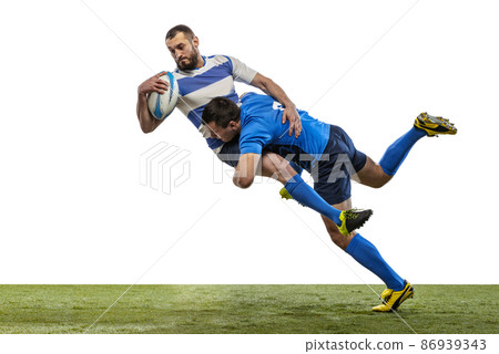 Dynamic portrait of male rugby players playing rugby football on grass field isolated on white background. Sport, activity, health, hobby, occupations concept Dynamic portrait of male rugby players playing rugby football on grass field isolated on white background. Sport, activity, health, hobby, occupations concept 86939343