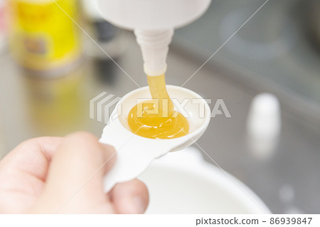 手把蜂蜜放在勺子裡 86939847