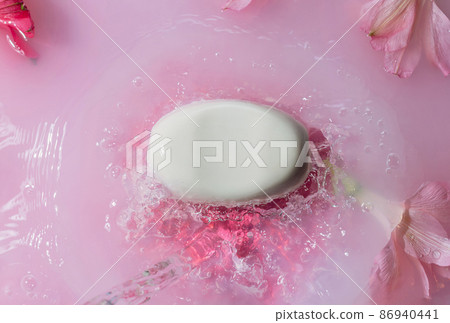 White soap bar in pink splashing water with flowers, body care concept, White soap bar in pink splashing water with flowers, body care concept, 86940441