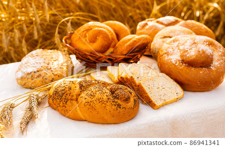 lot of different flavored bread, wheat, rye, on the table in the field outside lot of different flavored bread, wheat, rye, on the table in the field outside 86941341