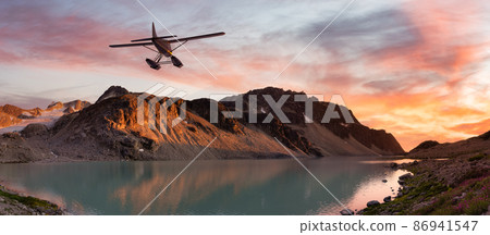 Seaplane Flying over the Glacier Lake and Mountains Landscape at sunset 86941547