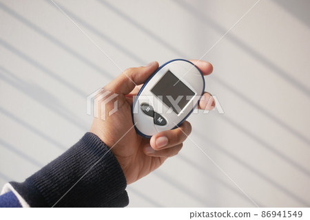 man's hand measuring blood sugar level man's hand measuring blood sugar level 86941549