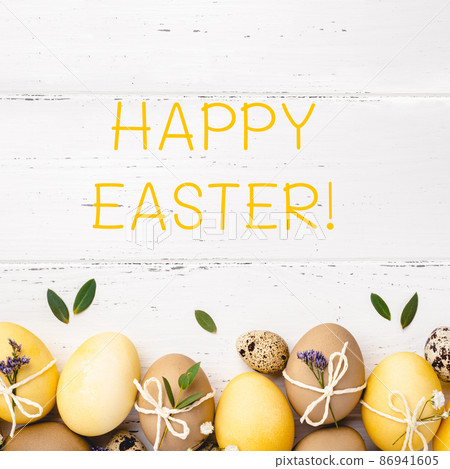Festive Easter background. Easter eggs with flowers on a white table. Flat lay, place for text. Festive Easter background. Easter eggs with flowers on a white table. Flat lay, place for text. 86941605