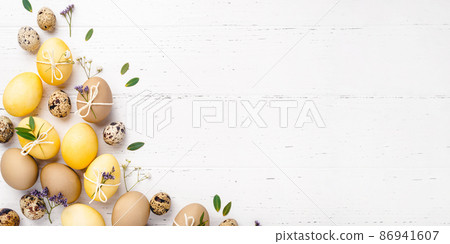 Festive Easter background. Easter eggs with flowers on a white table. Flat lay, place for text. Festive Easter background. Easter eggs with flowers on a white table. Flat lay, place for text. 86941607