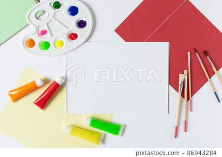 Pain brushes, watercolours and paint palette top view with blank sketchbook on white background. Pain brushes, watercolours and paint palette top view with blank sketchbook on white background. 86943284