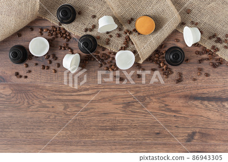 Espresso coffee capsules and roasted coffee beans on wooden background top view. 86943305