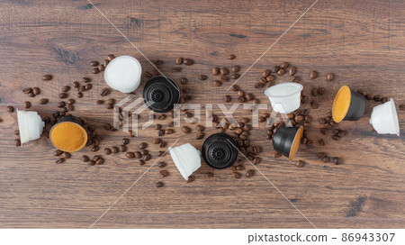 Espresso coffee capsules and roasted coffee beans on wooden background top view. 86943307