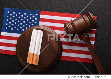 Tobacco law in United States of America. Cigarettes, wooden Judge gavel and flag of USA. Tobacco control act Tobacco law in United States of America. Cigarettes, wooden Judge gavel and flag of USA. Tobacco control act 86944960