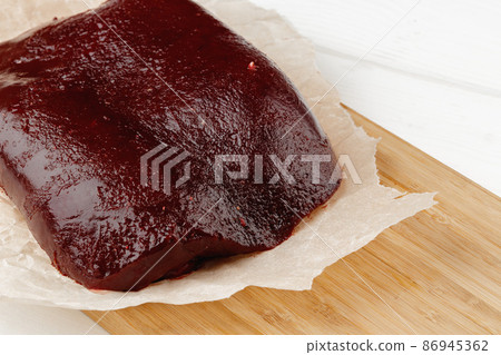 Raw beef liver on wooden board on table Raw beef liver on wooden board on table 86945362
