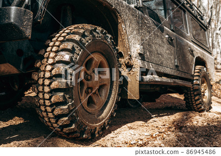 Wheel of offroad car in a muddy roadn forest 86945486