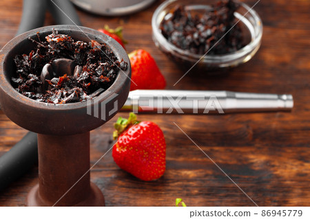 Hookah parts and strawberry on gray surface close up Hookah parts and strawberry on gray surface close up 86945779