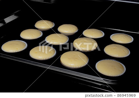 Twelve cupcakes, muffins baking in electric oven 86945969