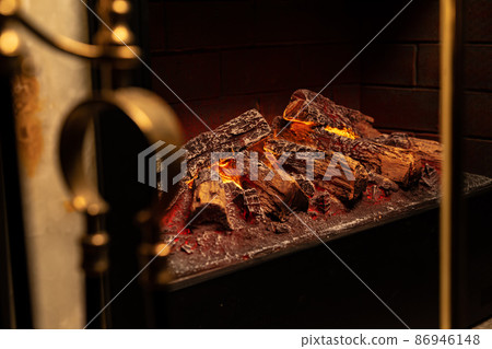 Close up of a fireplace with burning wood logs inside Close up of a fireplace with burning wood logs inside 86946148