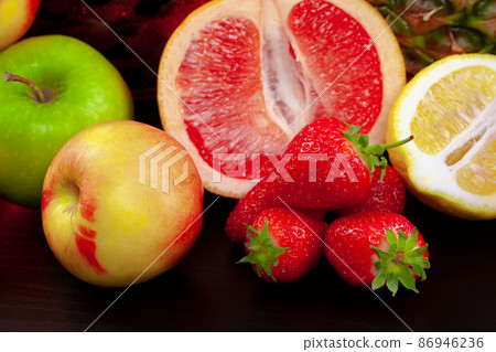 Grapefruit, strawberries and apple on black background Grapefruit, strawberries and apple on black background 86946236