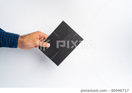 Male hand holding closed envelope above the white surface Male hand holding closed envelope above the white surface 86946717