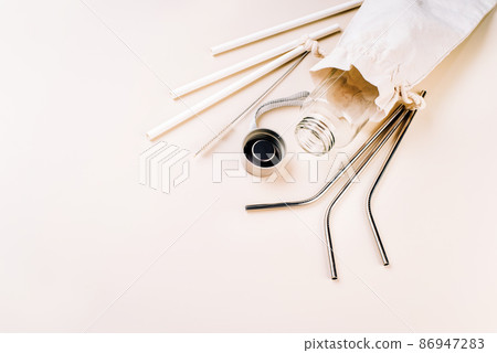 Zero waste and eco friendly,plastic free concept.Reusable glass bottle on white background.Cotton bag,glass bottle and metal reusable and paper disposable tubes.Copy space.Ecological,natural materials 86947283