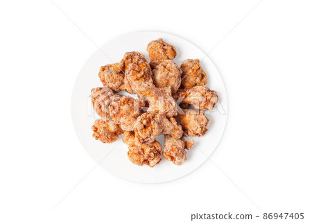 Frozen semi-cooked chicken wings on a white plate on a white background.Fast food, convenience food. Frozen semi-cooked chicken wings on a white plate on a white background.Fast food, convenience food. 86947405
