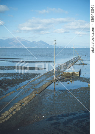 Nagabeta Seabed Road that appears only at low tide in the Ariake Sea and Mt. Unzen Fugen, Nagasaki Prefecture on the opposite bank --Sumiyoshi Kaihin Park, Uto City, Kumamoto Prefecture, Japan 86948843