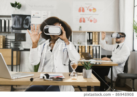 Diverse doctors using VR headset while working at hospital 86948908