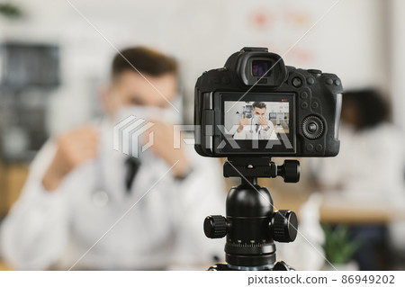 Doctor recording video about medical face mask Doctor recording video about medical face mask 86949202