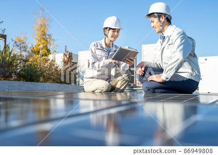 Businessmen and female workers checking solar panels 86949808