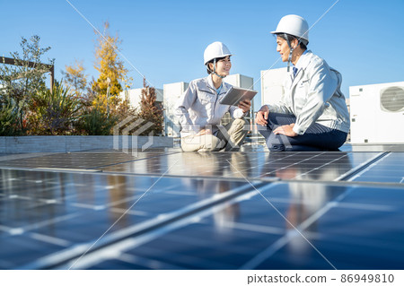 Businessmen and female workers checking solar panels 86949810