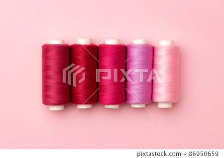 Set of threads spools on pink background Set of threads spools on pink background 86950659