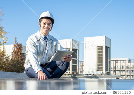 A businessman checking a solar panel A businessman checking a solar panel 86951130