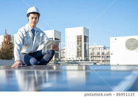 A businessman checking a solar panel A businessman checking a solar panel 86951135