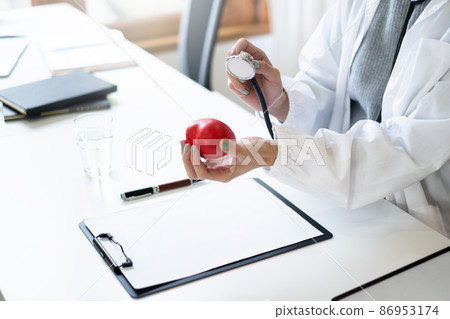 Portrait of doctor smiling wearing eyeglasses and showing stethoscope tools at office in private clinic. Medicine and health care and insurance concept. 86953174
