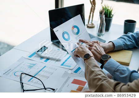Two accountant discussion analysis sharing calculations about the company budget and financial planning together on desk at the office room 86953429