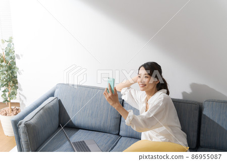 Woman operating a smartphone Woman operating a smartphone 86955087